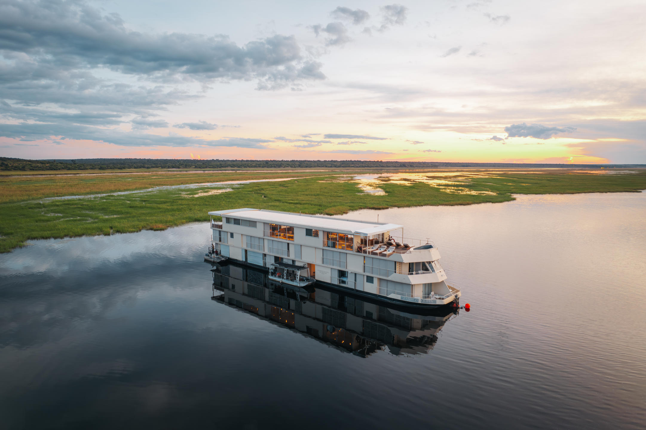 The Zambezi Queen luxury houseboat on the Chobe River, Botswana, offering an upscale river safari experience for charity auction lots.